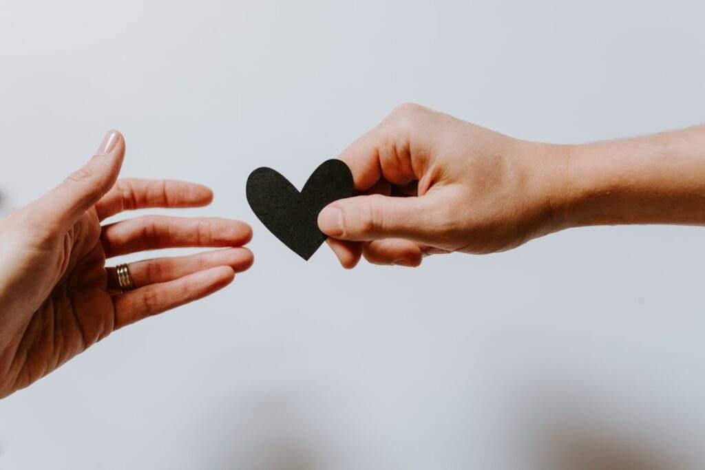 Deux mains qui se donnent un coeur en papier